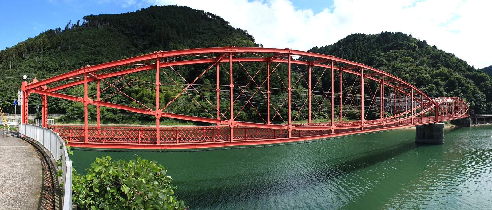 水面に架かる赤い南河内橋。二つのレンズ形が連なる姿