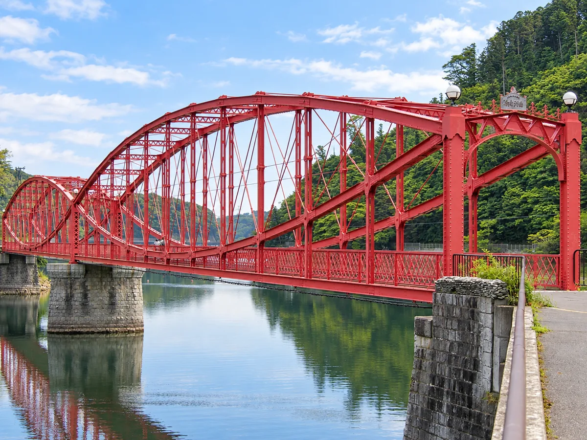 手前の石造りの橋台と赤いトラスを斜めから見た南河内橋
